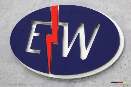 Firmenschild mit 3D-Logo aus farbigem Acrylglas. E+W - Mehrlagiges 3D-Logo aus Acrylox