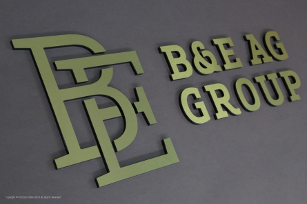 B&E AG - Goldenes Logo aus gebürstetem Dibond-Butlerfinish
