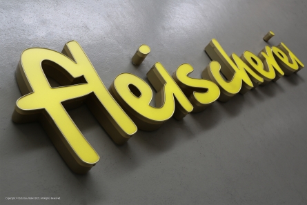 Goldene LED-Profilbuchstaben aus Aluminium und Plexiglas.
